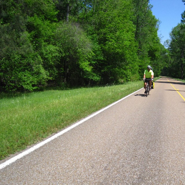 A bicyclist with a lime green t-shirt.
