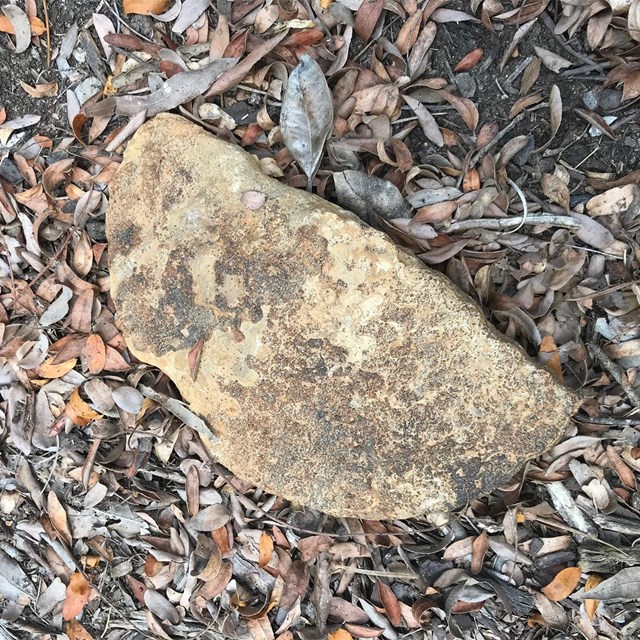 A crescent shaped stone that appears to be chipped to that shape.