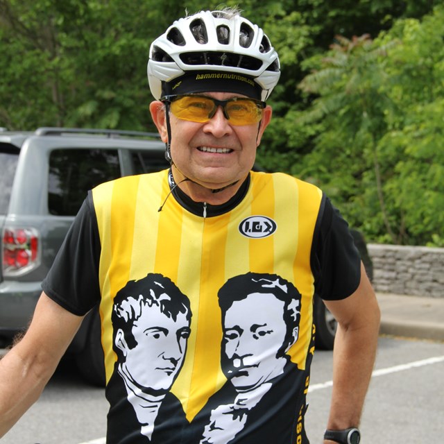 A bicyclist wearing a shirt with Meriwether Lewis and Andrew Jackson
