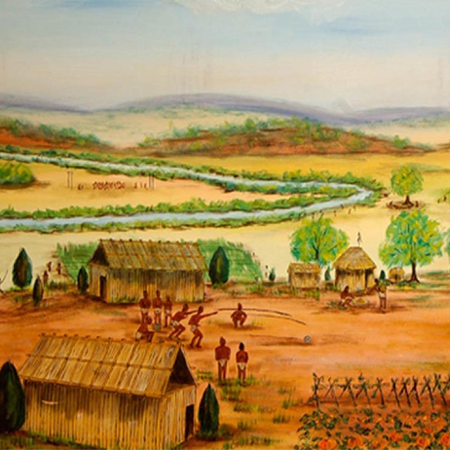 An American Indian village overlooking an agricultural field.