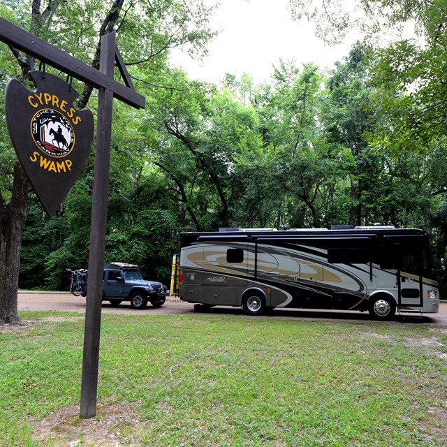 An RV parked at the Cypress Swamp site.