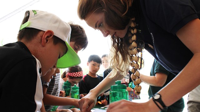 A volunteer sits and examines pieces of paper with a child