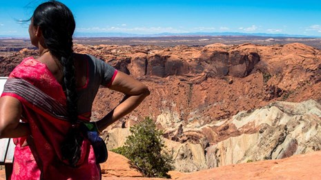 a woman looks out over a canyon
