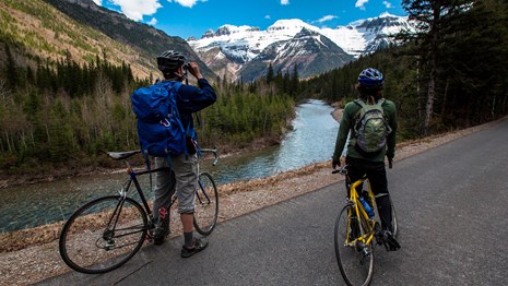 Two bicyclists standing on road