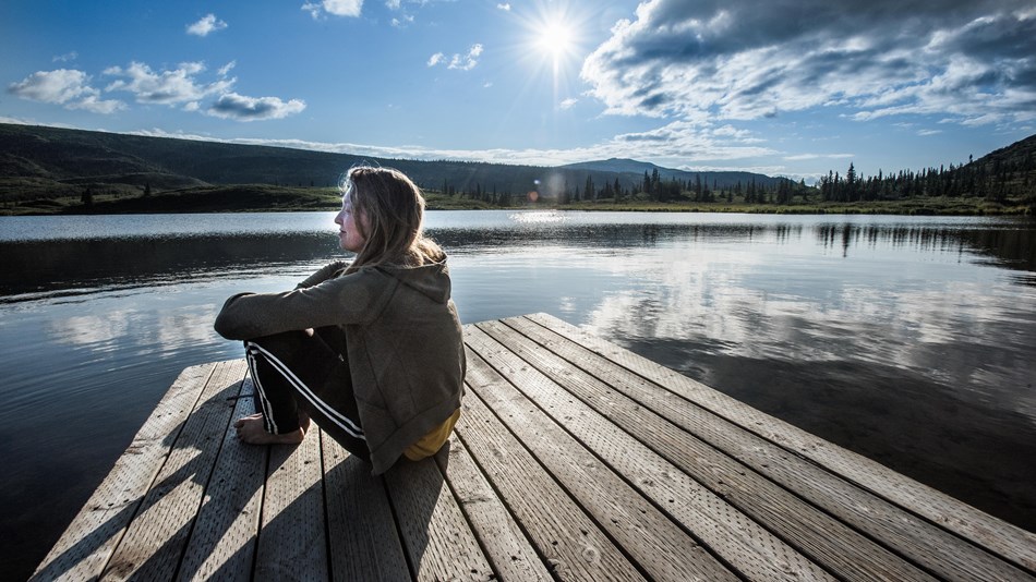 woman sitting by lake
