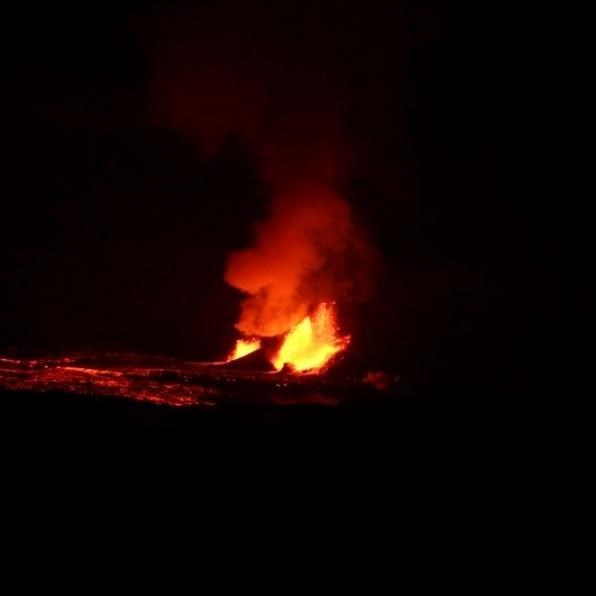 The red glow of lava in an erupting caldera at night