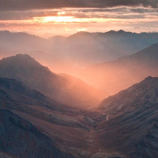 Pink light shines through a valley in the Brooks Range