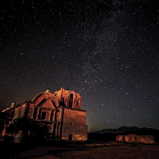 a historic mission at night under a starry sky