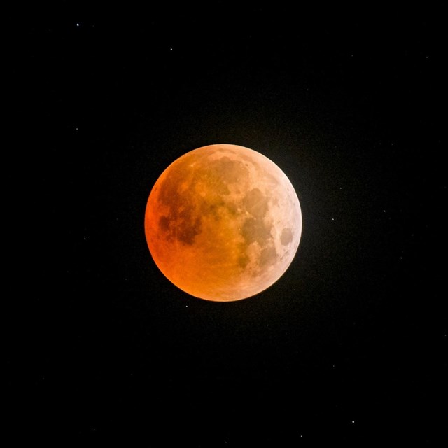 a glowing orange moon during a lunar eclipse