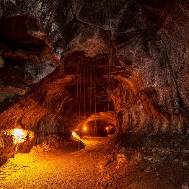 a dark cave illuminated in orange light 