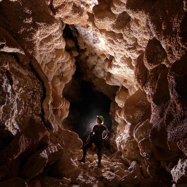 person standing in a large underground passageway  