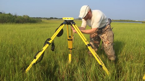 crew sets up the RTK GPS equipment in preparation for data collection on the marsh
