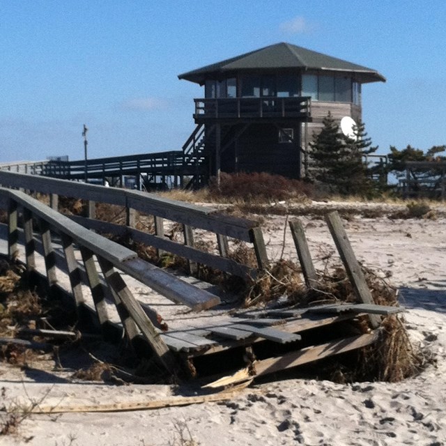 a boardwalk on the beach is torn up by a flood