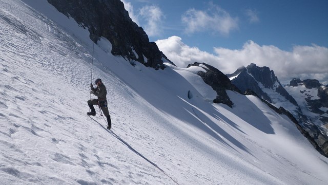 person taking measurements on a glacier