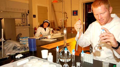 Lydia Archuleta and Seth Fornea are working at the benches in the Clean Lab.