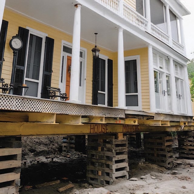 A house lifted on wooden beams