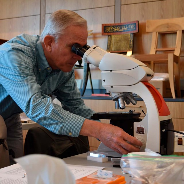 Report cover with image of man looking in microscope.