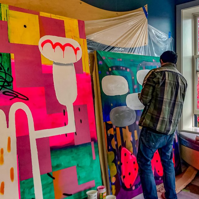 Bright colorful murals with artists Nick Mello painting 