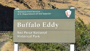 A green sign with the words "Buffal Eddy Nez Perce National Historical Park."
