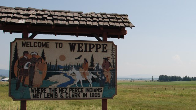 Wooden sign that reads "Welcome to Weippe where the Nez Perce Indians met Lewis and Clark in 1805."