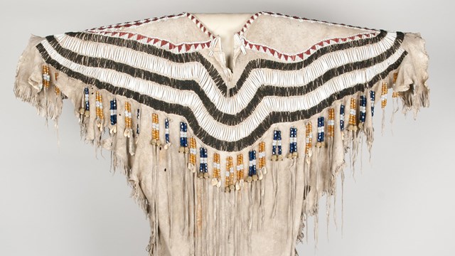 Woman's dress made of two deer skins and decorated with glass beads, dentalium, thimbles, elk teeth,