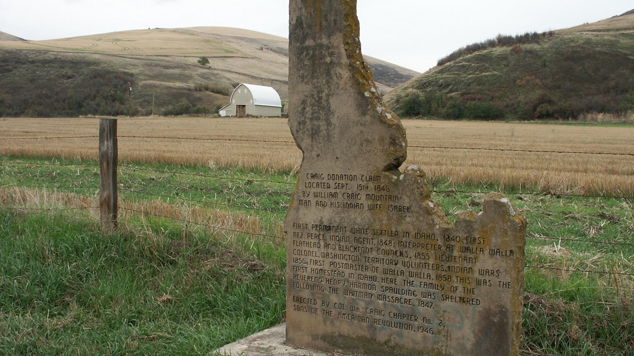 A monument in the shape of Idaho on the side of the road.