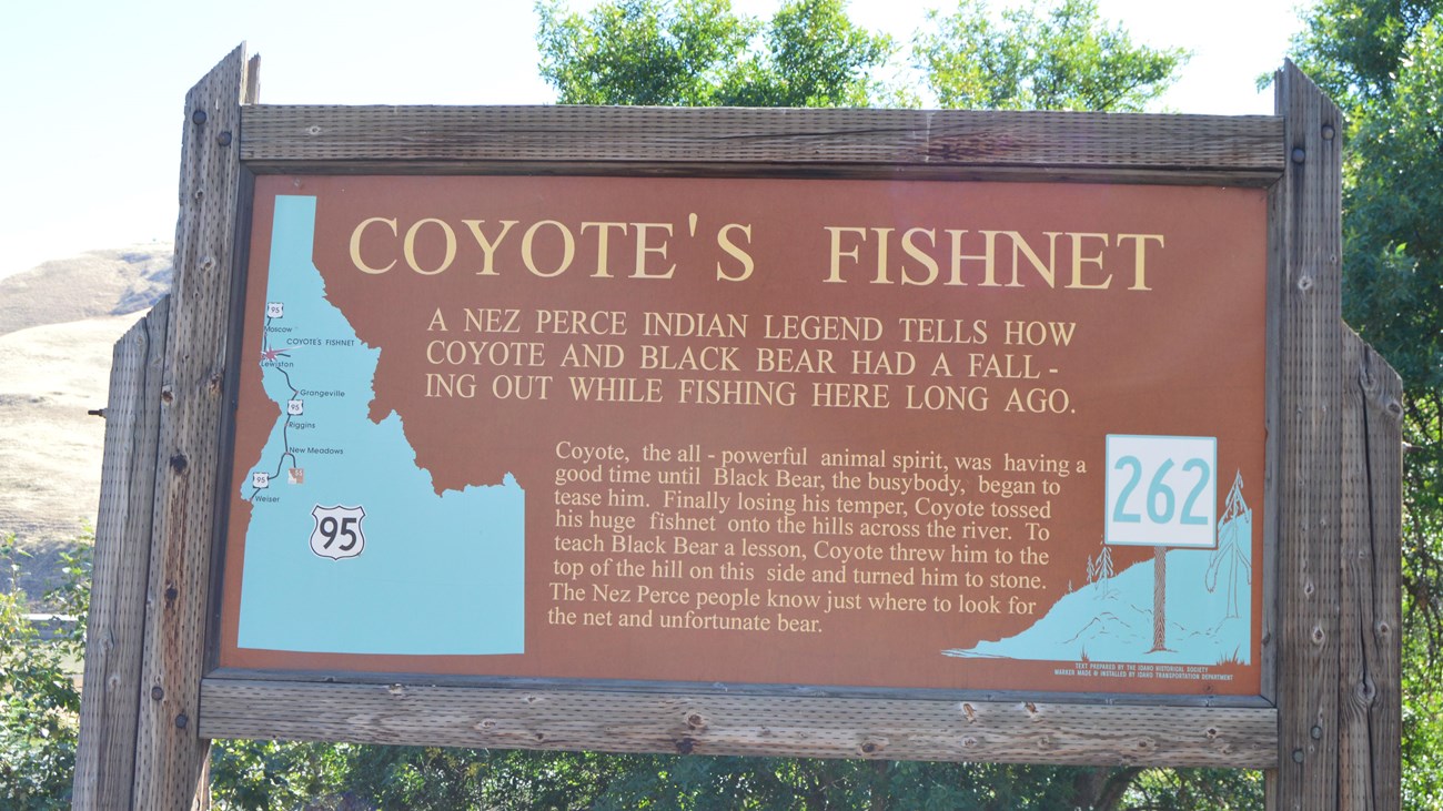 A dark brown information sign with the words 'Coyote's Fishnet' on it.