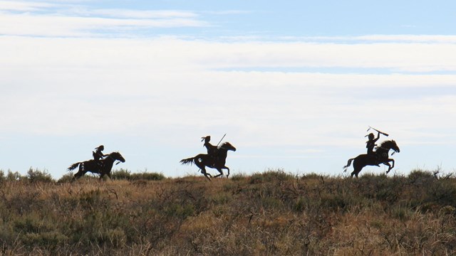 Three silhouettes of Nez Perce warriors on horseback 