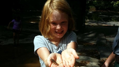 young girl holding a crayfish