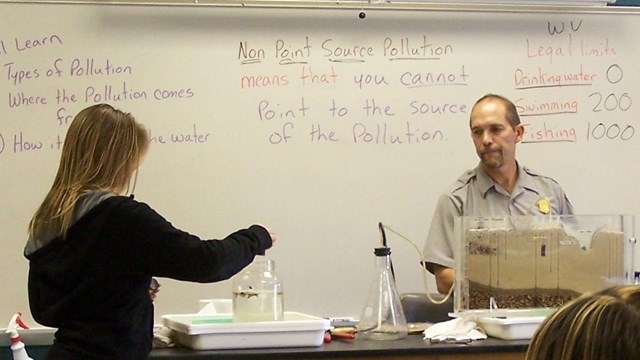 ranger with students presenting water pollution lesson