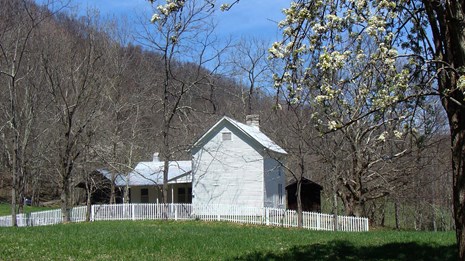 white farmhouse with a white picket fence