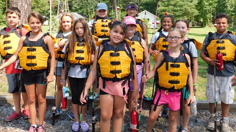 kids with life jackets preparing for a river trip