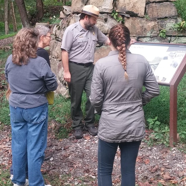 ranger talking to visitors at historic structure