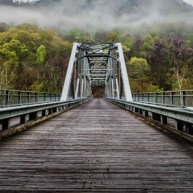 old bridge across river with fog