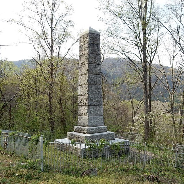 Stone pillar monument on a green hillside