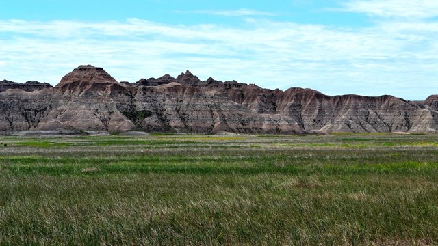 eroded rocky  bluffs with grassland in foreground
