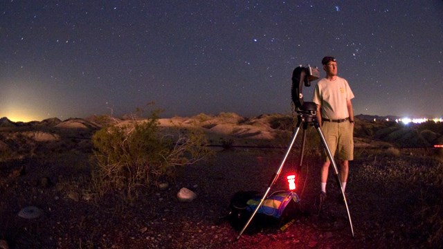 NPS scientist prepares cameras to measure sky glow conditions in the desert at night.
