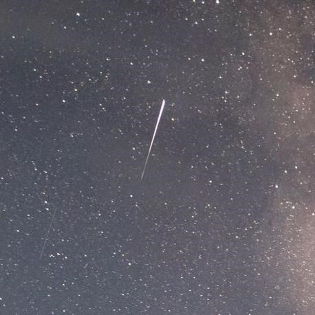a shooting star and milky way over a calm lake