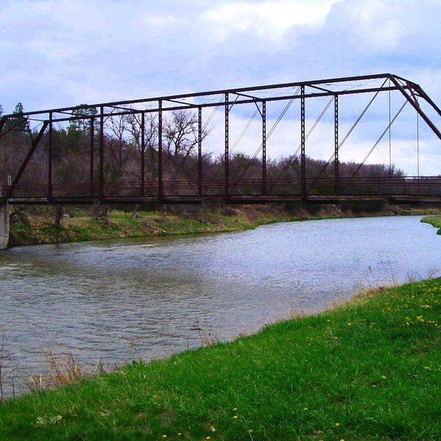 Brewer Bridge with metal suspensions and supports over the Niobrara River on a sunny day