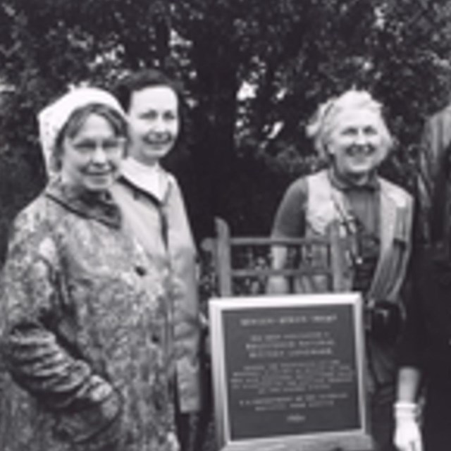 black and white image of people next to NNL plaque