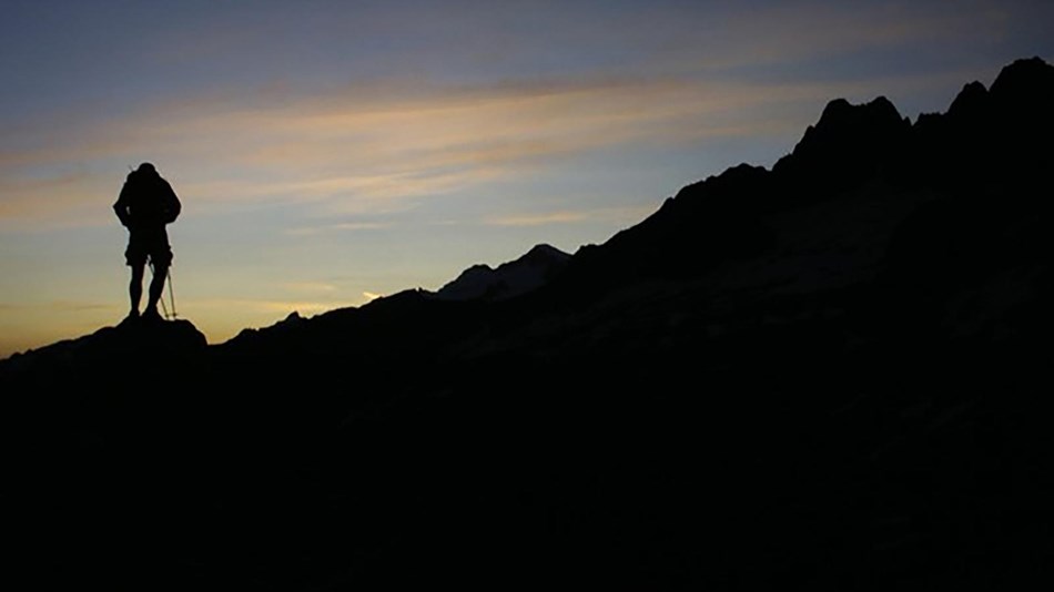 A hiker silhouette against a sunset 