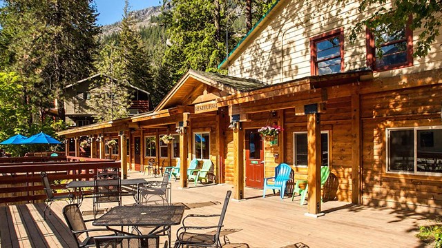 Table and chairs on the patio deck with the restaurant and lodge facilities in the background. 