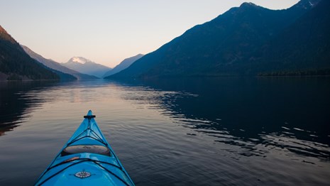 A kayak floats on a still lake.