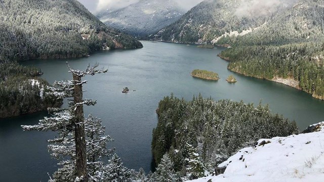 Looking out over a lake and mountains dusted with snow.