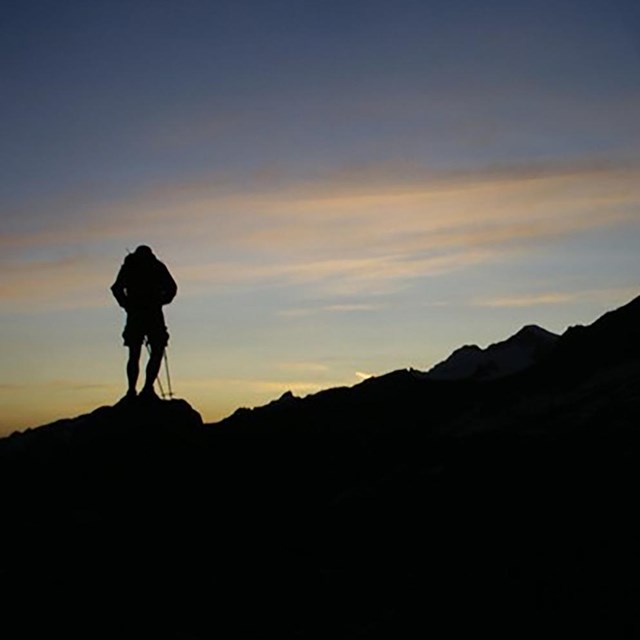 A hiker silhouette against a sunset 