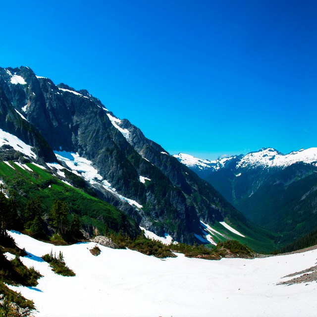 View of a valley with mountains in the distance on a clear day
