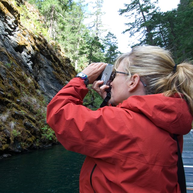 A woman takes a picture from a boat
