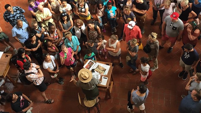 An aerial view of a crowd gathering for a tour around a park ranger