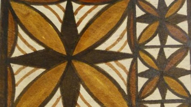 Indoors; close-up of flat art piece depicting geometric shapes in shade of brown.