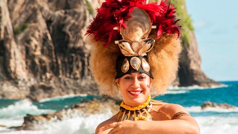 A cheerful Taupou--Samoan princess wears a colorful head dress.